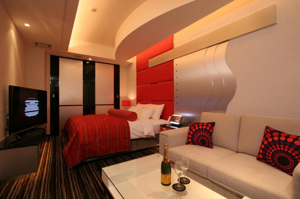 un salon avec un canapé et un lit dans l'établissement HOTEL W-PREMIUM -W GROUP HOTELS and RESORTS-, à Koshigaya