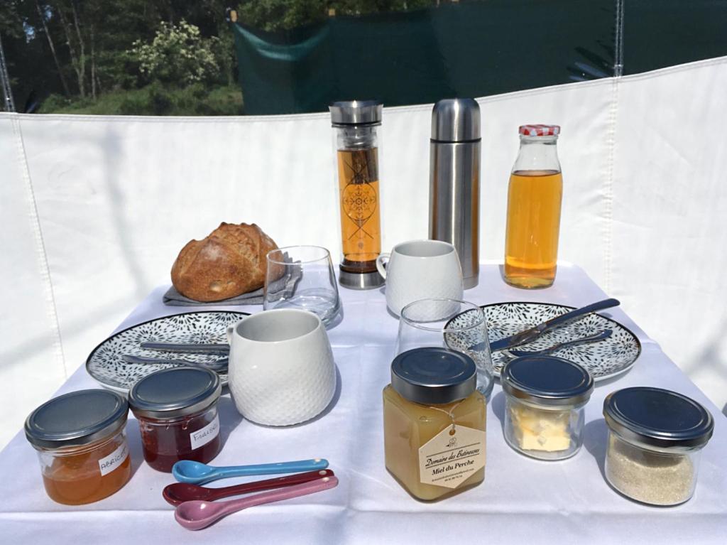 - une table avec des bocaux et des bouteilles de miel et de nourriture dans l'établissement domaine des butineuses, à Marchainville 18 autres photos