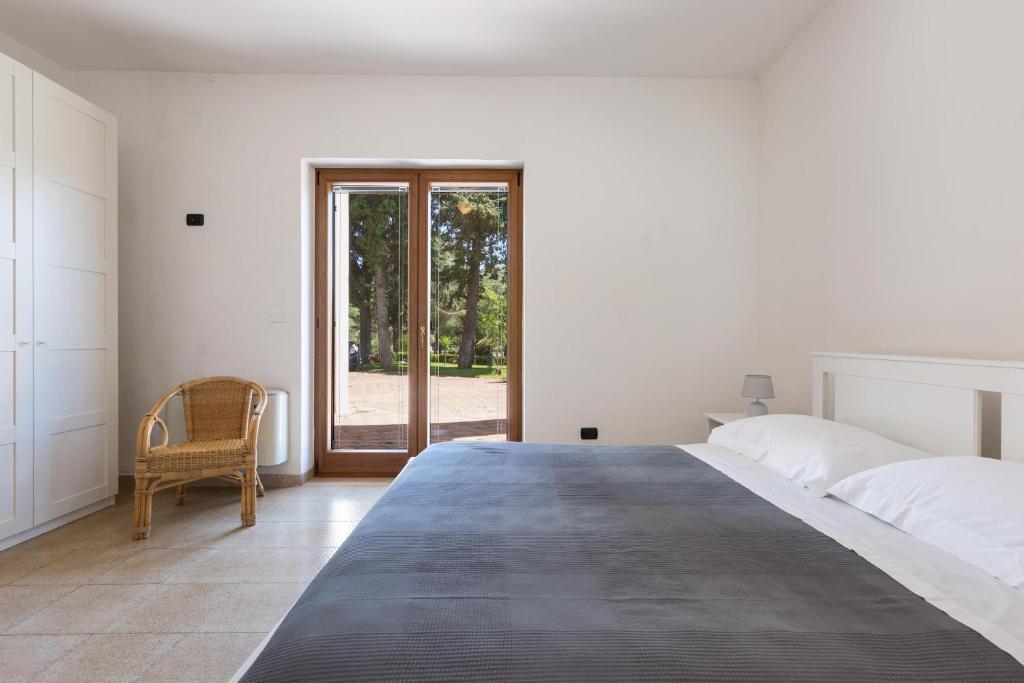une chambre blanche avec un grand lit et une fenêtre dans l'établissement Villa Emary by Perle di Puglia, à San Vito dei Normanni