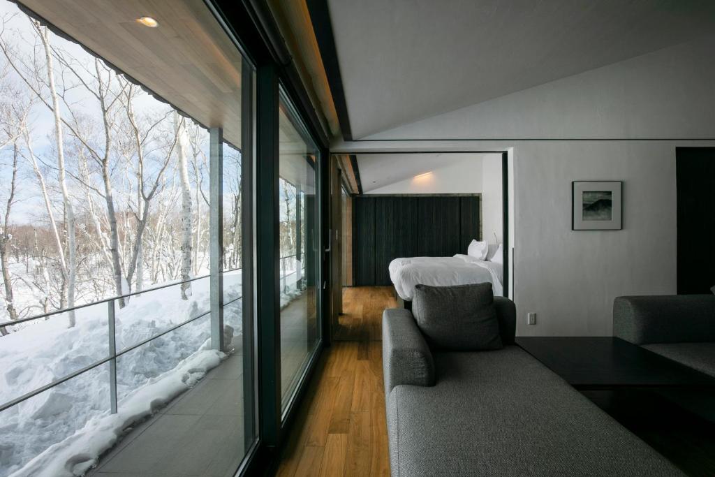 Cette chambre dispose d'un canapé, d'un lit et d'une fenêtre. dans l'établissement Zaborin, à Kutchan