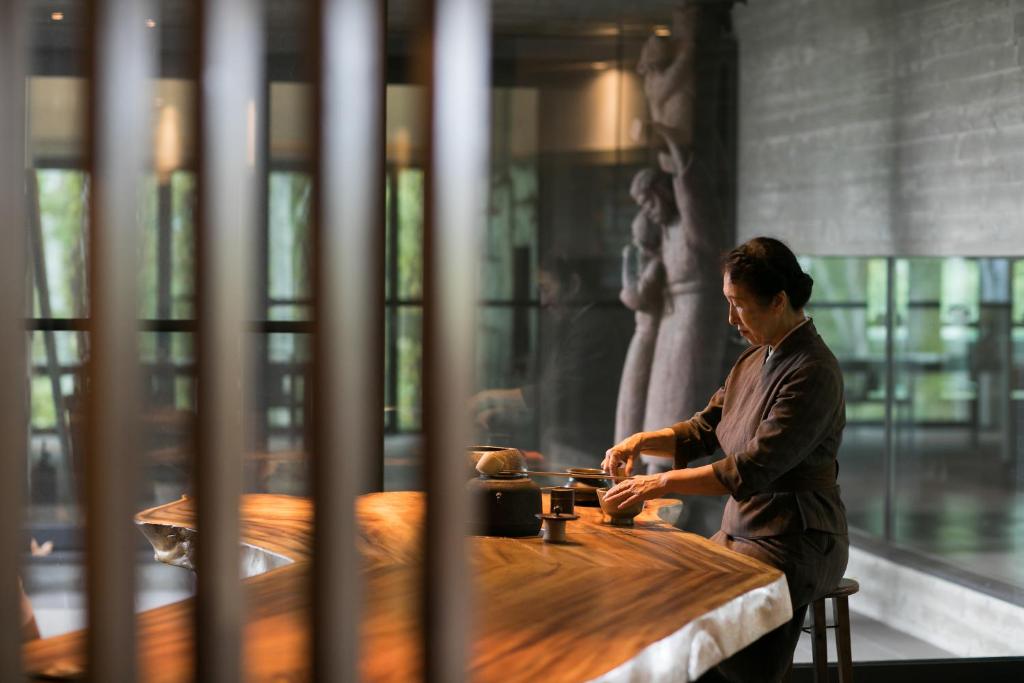 une femme assise à une table dans une pièce dans l'établissement Zaborin, à Kutchan