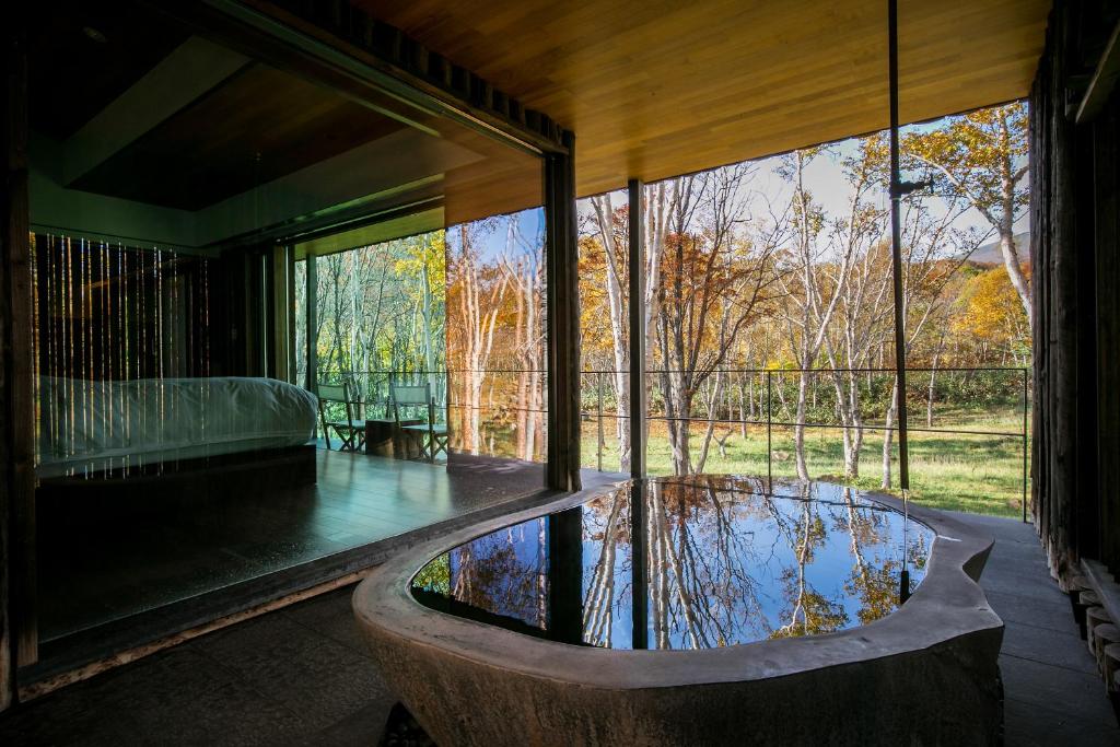 une chambre avec une piscine d'eau à l'intérieur d'une maison dans l'établissement Zaborin, à Kutchan