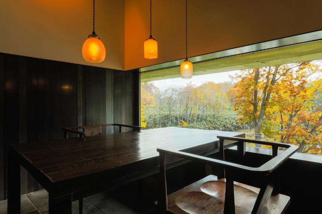 une salle à manger avec une table et une grande fenêtre dans l'établissement Zaborin, à Kutchan
