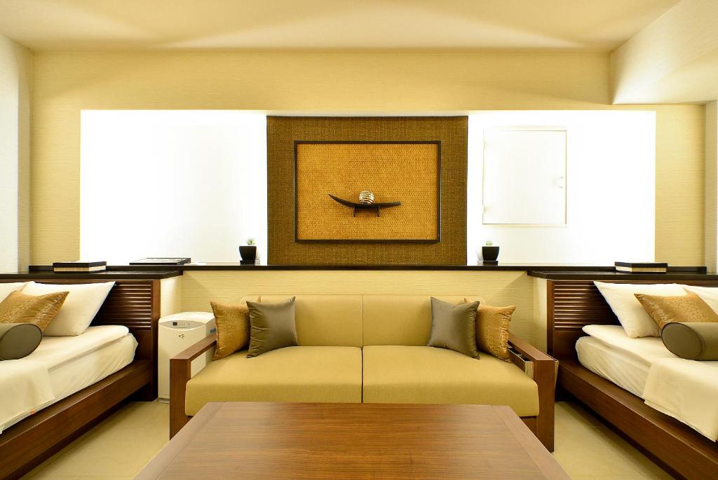 un salon avec deux lits et un canapé dans l'établissement AROMA+ (Adult Only), à Tokyo