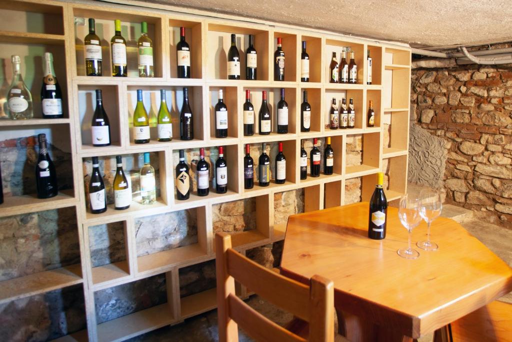 Cette chambre comprend une table et un bouquet de bouteilles de vin. dans l'établissement Villa Moiacchina Luxury Home, à Bevera