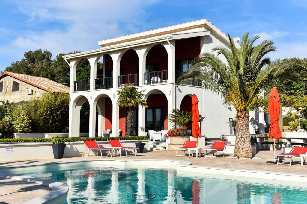 une villa avec piscine devant une maison dans l'établissement Villa Elena, à Camastra ex Solfara