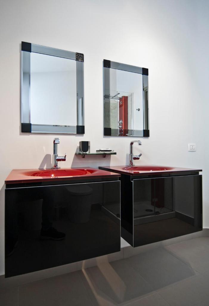 une salle de bain avec deux lavabos et deux miroirs dans l'établissement Villa Elena, à Camastra ex Solfara