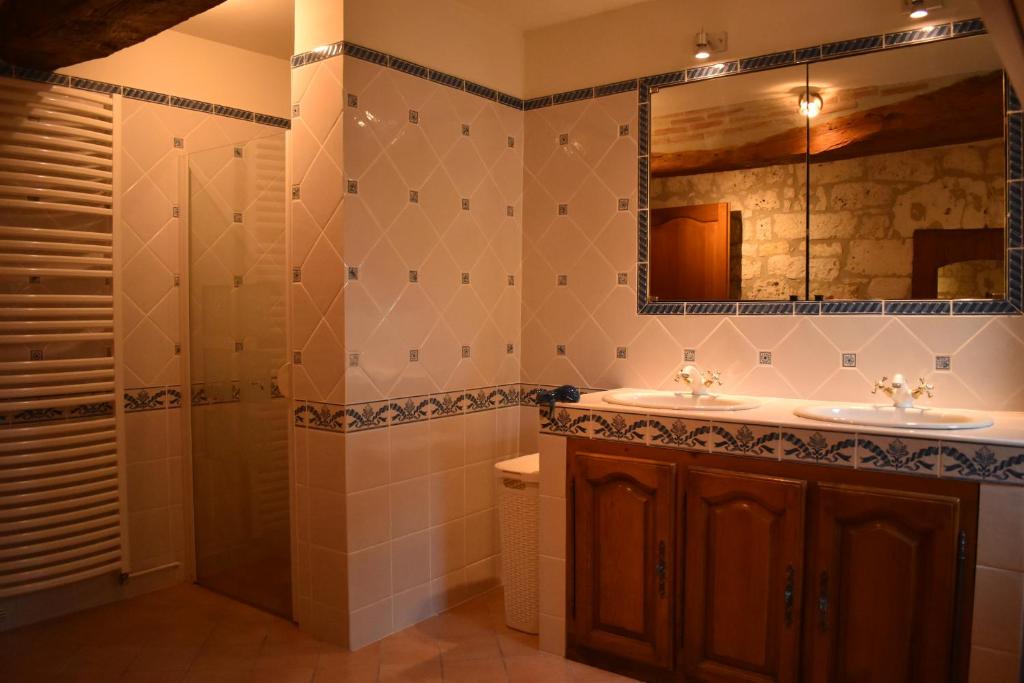 une salle de bain avec un lavabo, une douche et un miroir dans l'établissement Gites La Peyroulière, à Aurignac