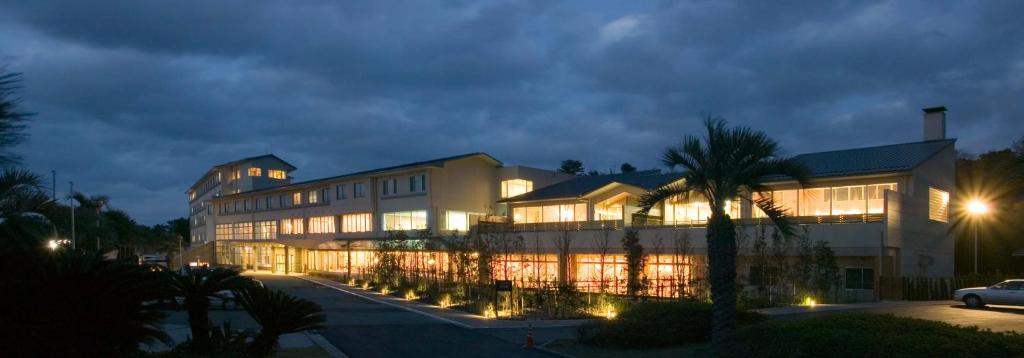 un grand bâtiment avec beaucoup de fenêtres la nuit dans l'établissement Kyukamura Shikanoshima, à Fukuoka