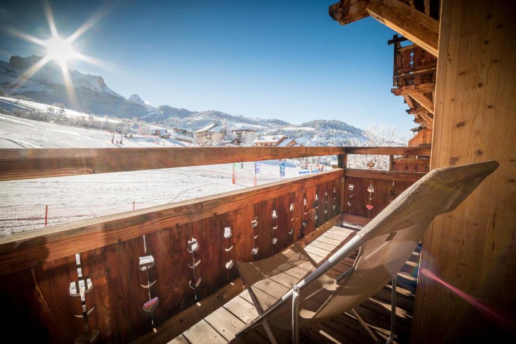 - un balcon en bois avec deux chaises sur une piste de ski dans l'établissement Montana Chalet Hôtel & Spa, au Sauze