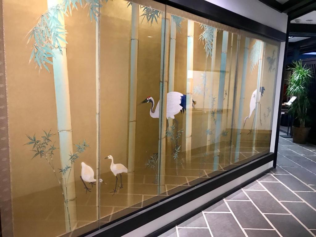 une fenêtre de visualisation d'un bâtiment comportant des oiseaux dans l'établissement Kyomachiya Ryokan Sakura Urushitei, à Kyoto 37 autres photos