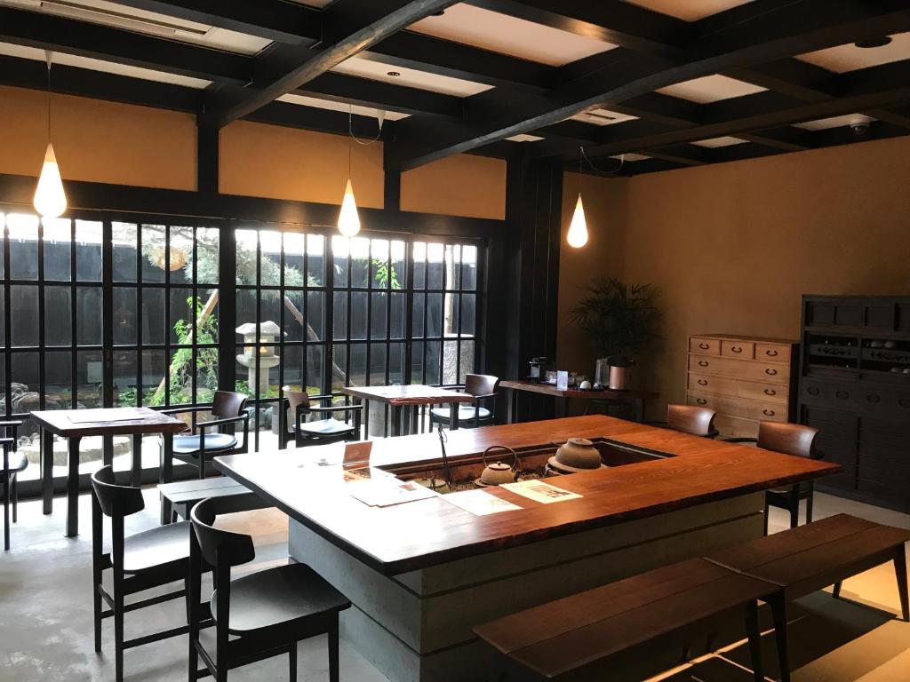 un restaurant avec des tables et des chaises et une grande fenêtre dans l'établissement Kyomachiya Ryokan Sakura Urushitei, à Kyoto