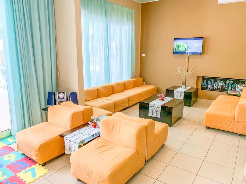 un salon avec des meubles orange et une télévision à écran plat dans l'établissement Hotel Zamagna, à Cesenatico