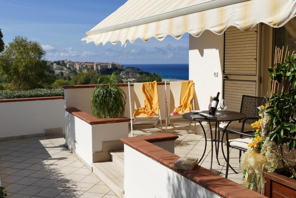 un patio avec une table et des chaises et l'océan dans l'établissement Hotel Tirreno, à Parghelia