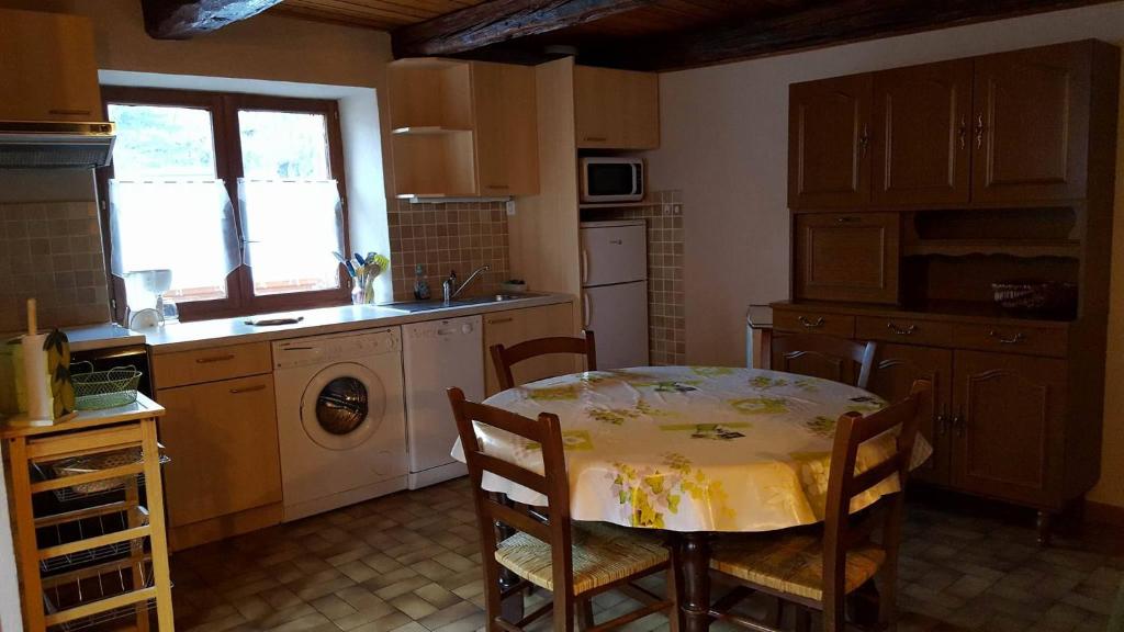 une cuisine avec une table et un chiffon de table jaune dans l'établissement Le balcon fleuri, à Freissinières