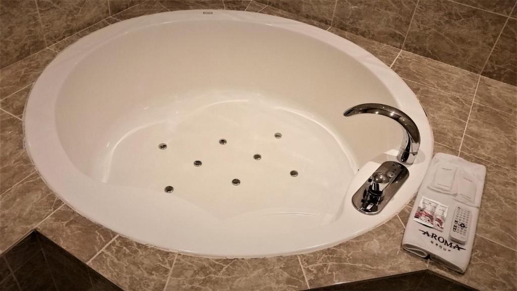 une baignoire avec un robinet dans une salle de bain dans l'établissement AROMA+ (Adult Only), à Tokyo