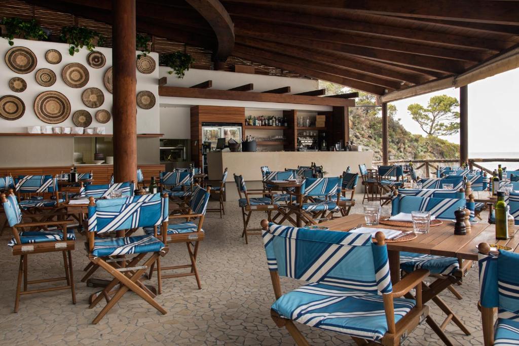 un restaurant avec des tables en bois et des chaises bleues dans l'établissement Mezzatorre Hotel & Thermal Spa, à Ischia