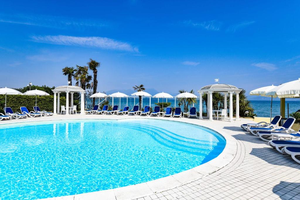une piscine avec chaises et parasols et l'océan dans l'établissement Lido International, à Desenzano del Garda 44 autres photos