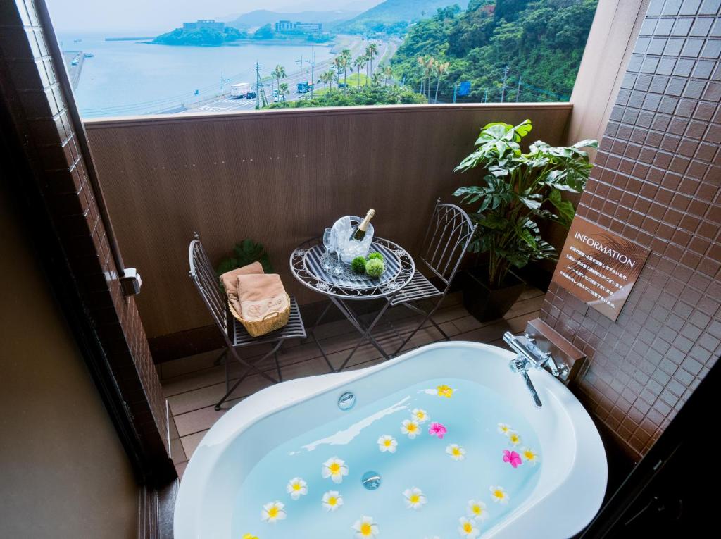 La salle de bains est pourvue d'une baignoire et offre une vue sur l'océan. dans l'établissement ホテルココナッツリゾートアミー Love Hotel, à Kagoshima