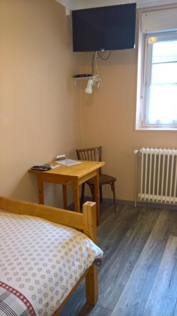 Cette chambre comprend un bureau et une table avec un lit. dans l'établissement Les Fauvettes, à Saint-Léger-les-Mélèzes