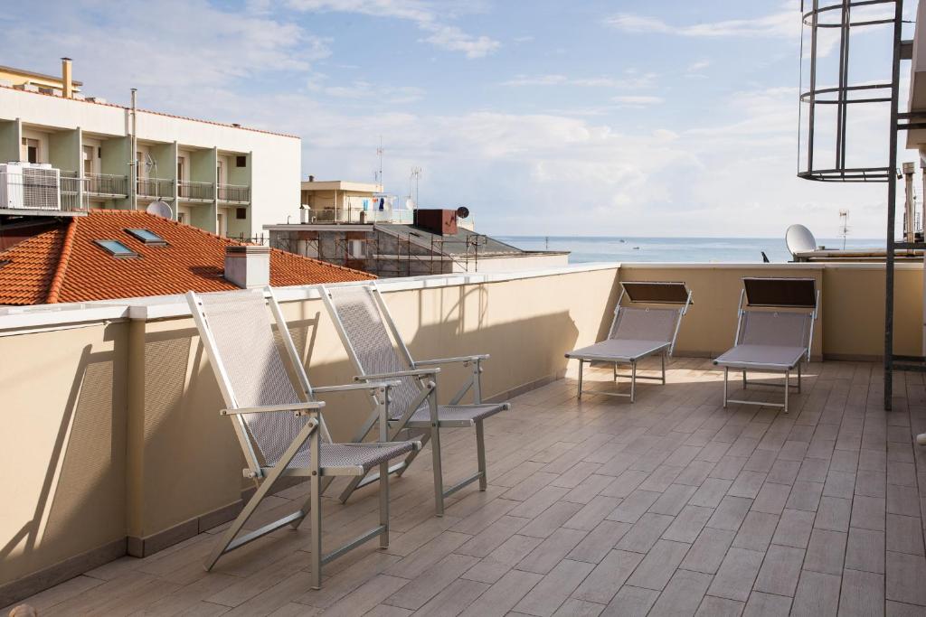 - une rangée de chaises sur un balcon donnant sur l'océan dans l'établissement Hotel Plaza, à Rimini