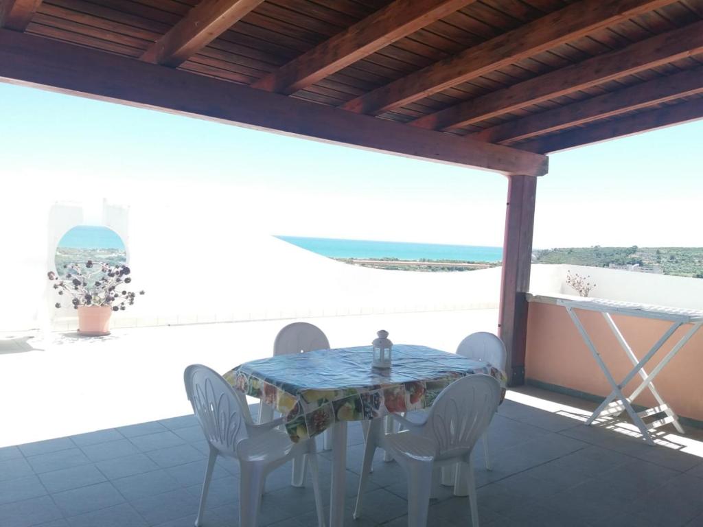 une table et des chaises sur une terrasse avec vue sur l'océan dans l'établissement Villa dei pini, à Vieste