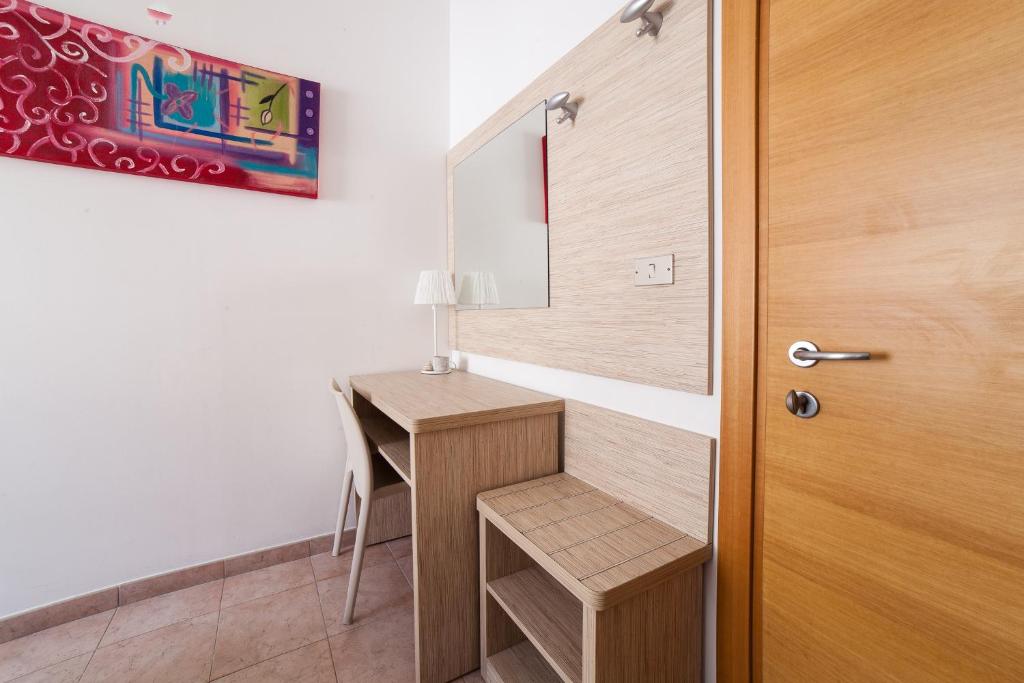 Cette chambre dispose d'un bureau et d'une porte en bois. dans l'établissement Hotel Plaza, à Rimini