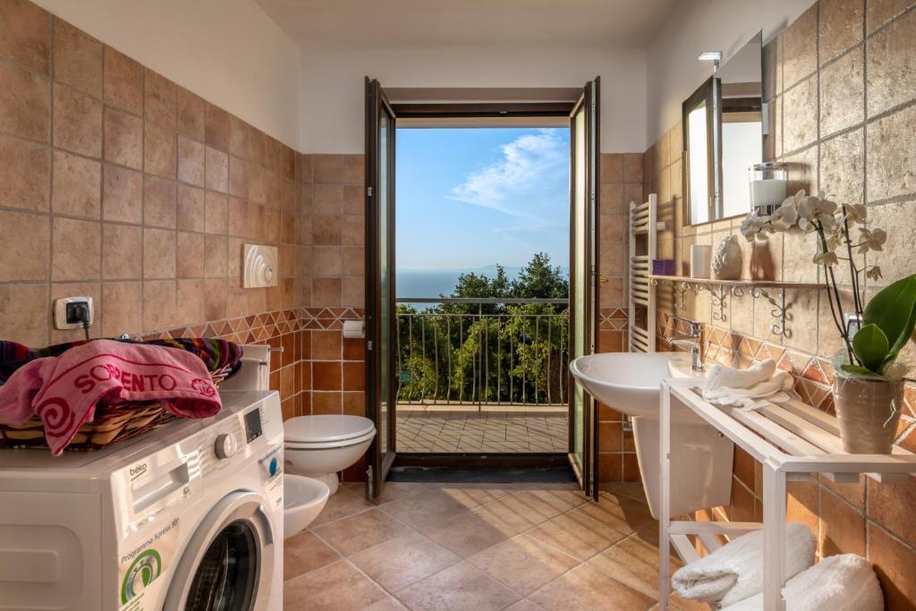 d'une salle de bains avec lave-linge et sèche-linge et d'un balcon. dans l'établissement Villa Novanta, à Massa Lubrense