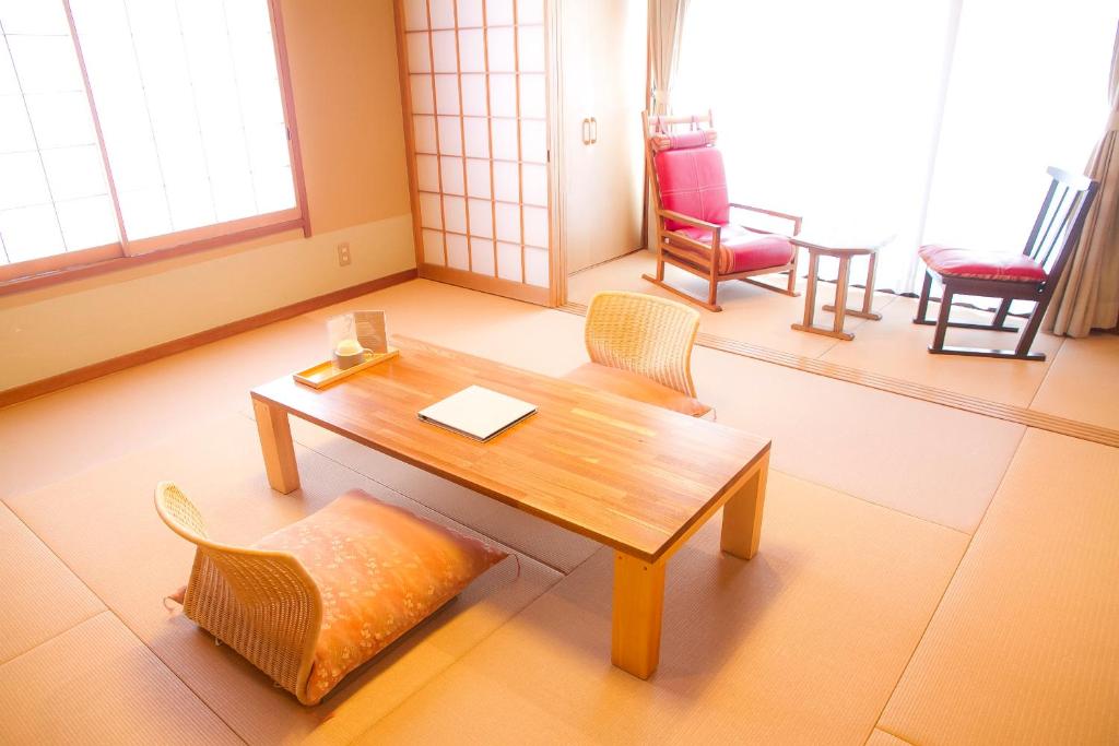 une pièce avec une table et des chaises dans une pièce dans l'établissement Yugawara Retreat Goen no Mori, à Yugawara