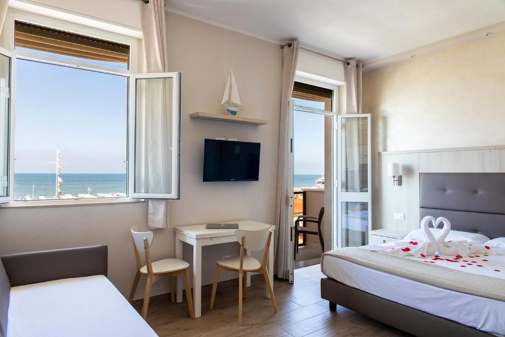 - une chambre avec un lit et un bureau avec une table dans l'établissement Hotel Biagi & Residence, à Lido di Camaiore