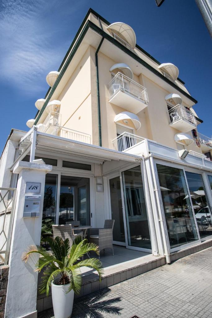 - un bâtiment avec de grandes portes vitrées et une terrasse dans l'établissement Hotel B&B Sole, à Senigallia