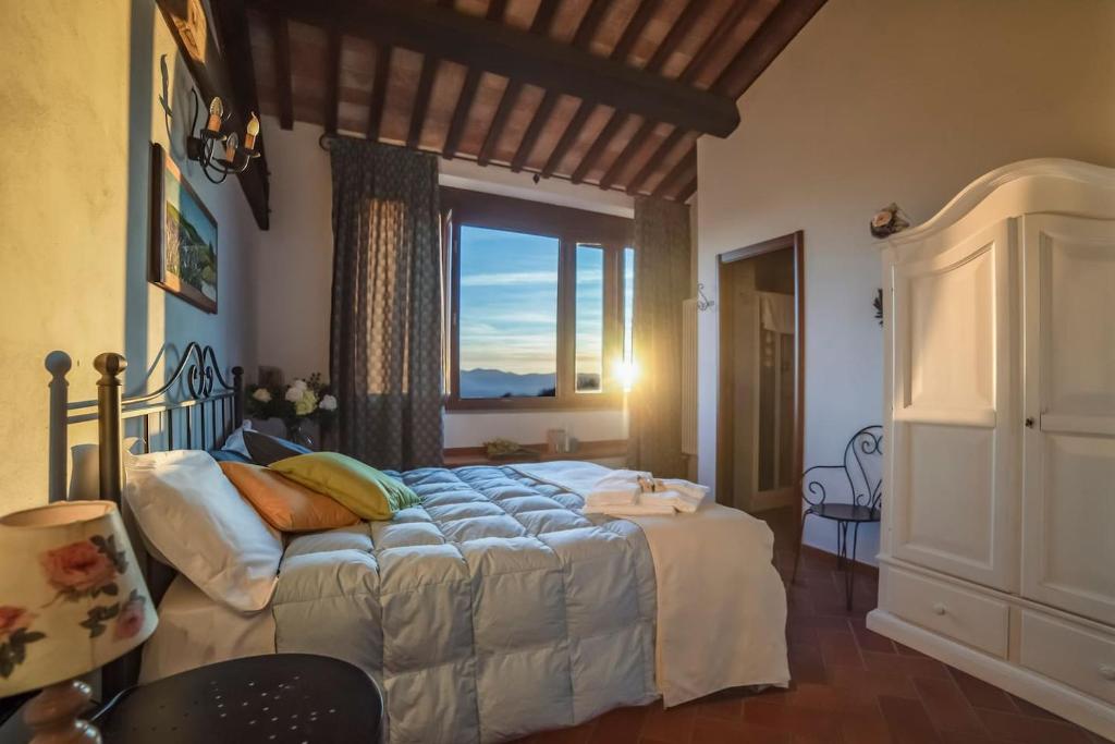 une chambre avec un lit et une grande fenêtre dans l'établissement Villa San Giorgio, à Montemurlo