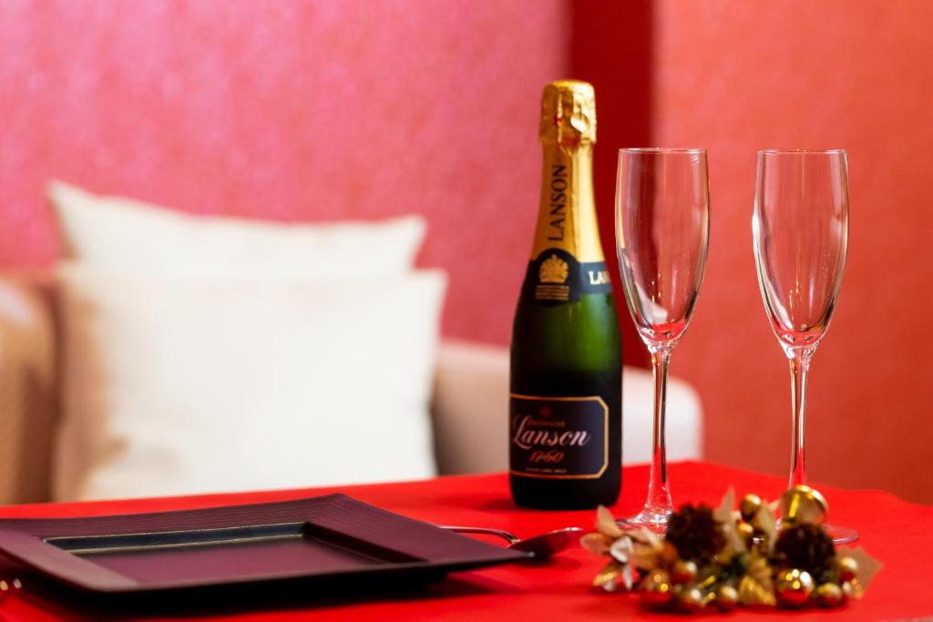 - une bouteille de champagne et deux verres sur une table dans l'établissement Fukuoka Little Chapel Christmas (Love Hotel), à Fukuoka
