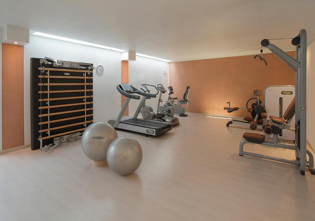 une salle de sport avec plusieurs appareils d'exercice dans une pièce dans l'établissement Iseo Lago Hotel, à Iseo