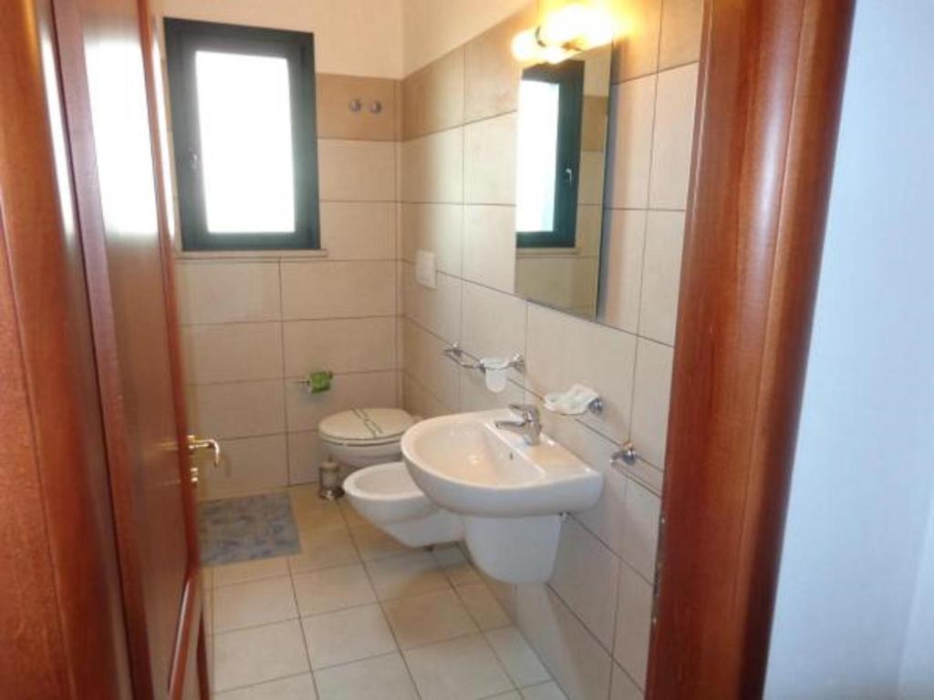 une salle de bain avec un lavabo et des toilettes dans l'établissement Residence Blu Mare, à Otrante