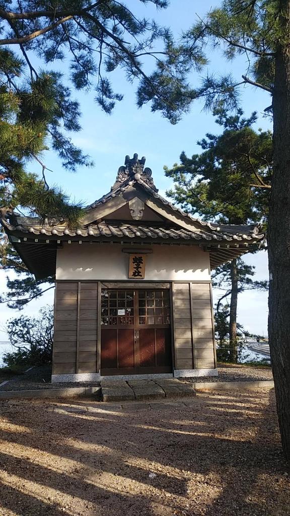 un bâtiment japonais avec un arbre devant lui dans l'établissement Minshuku Osaki, à Nishio