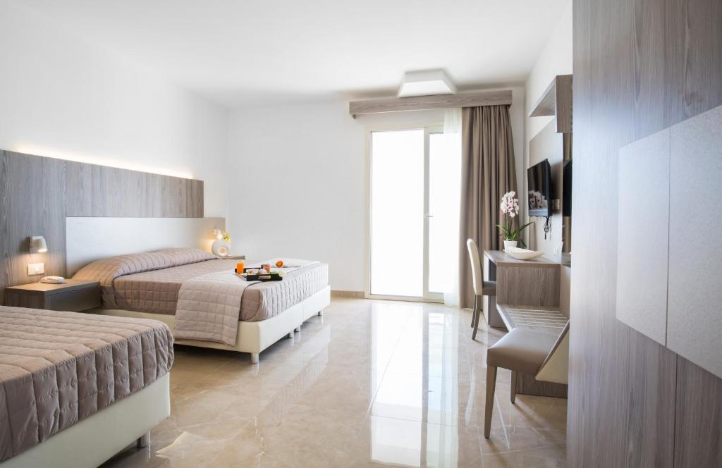 une chambre avec un lit et un bureau et un lit sidx sidx sidx dans l'établissement Forte 2 Hotel, à Vieste