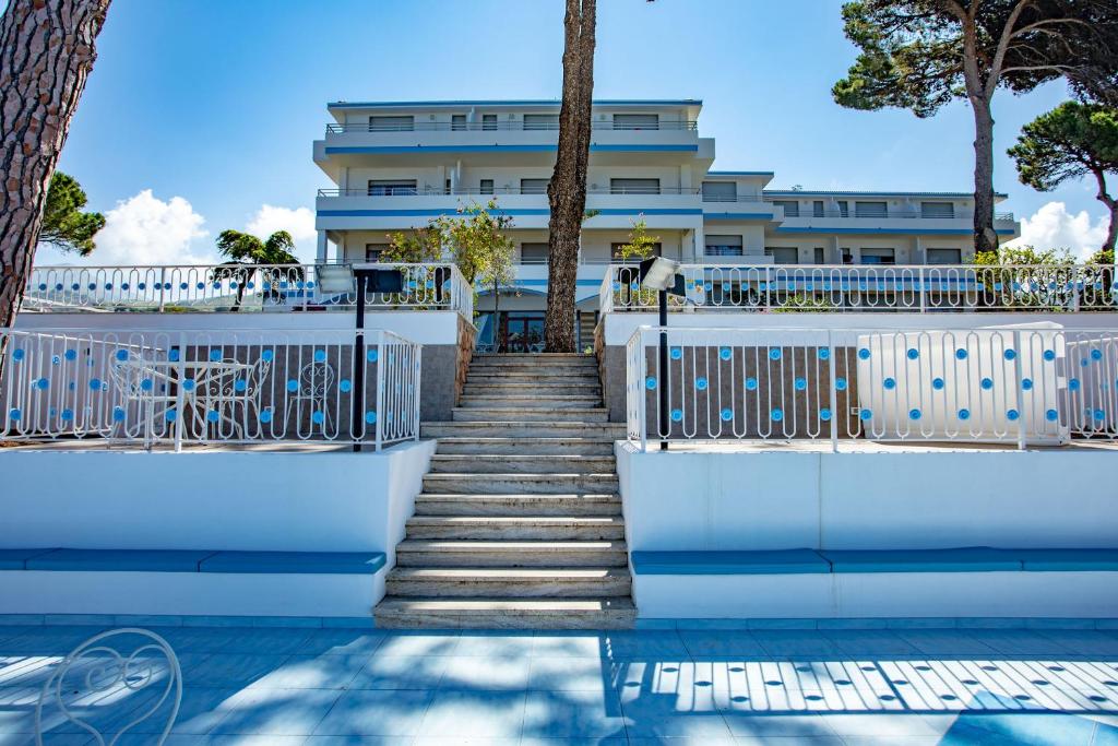 un escalier menant à une piscine avec un bâtiment dans l'établissement Hotel La Castellana, à Belvedere Marittimo