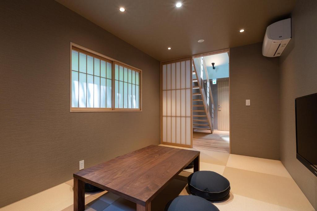 - un salon avec une table en bois et une fenêtre dans l'établissement Gunjo no Tsuki, à Kanazawa