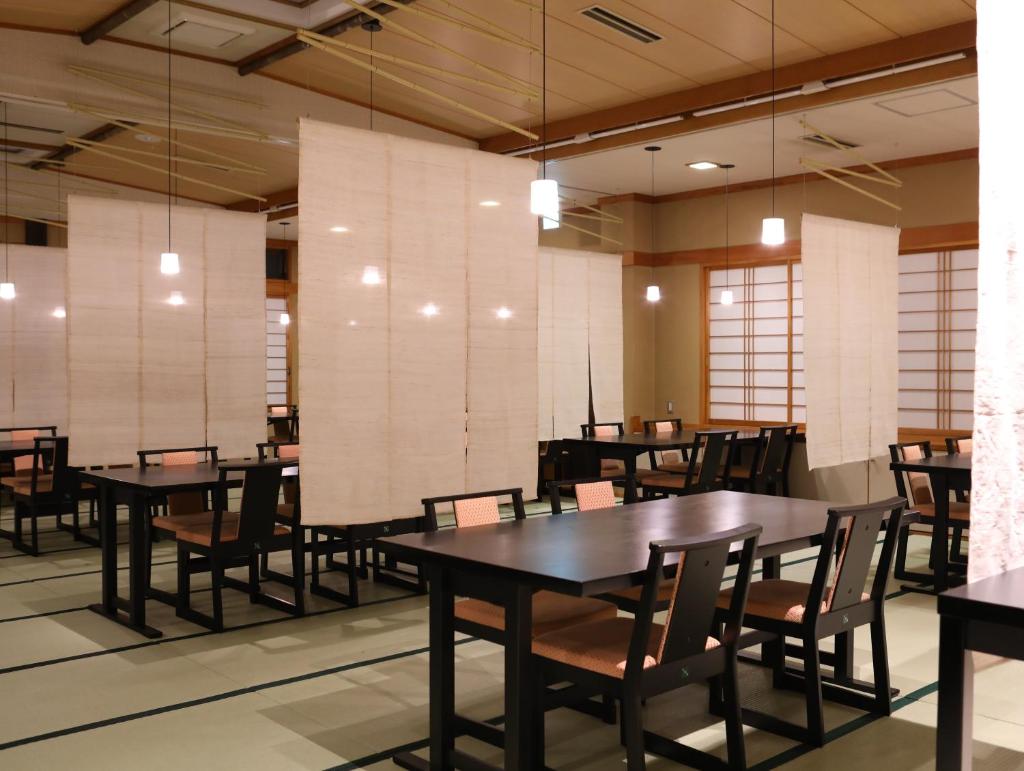 une salle à manger avec des tables et des chaises dans l'établissement Besshoonsen Nanjyo Ryokan, à Ueda