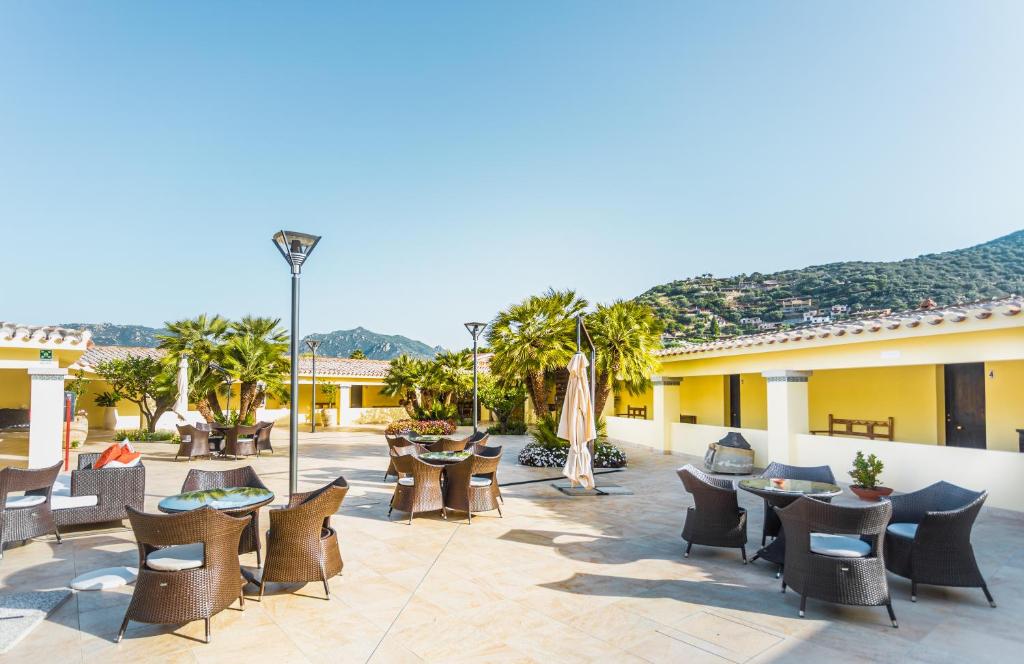 d'une terrasse avec des tables et des chaises. dans l'établissement Hotel Fiore Di Maggio, à Villasimius