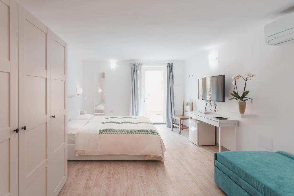 une chambre blanche avec un lit et un bureau dans l'établissement Hotel Fiore Di Maggio, à Villasimius 87 autres photos