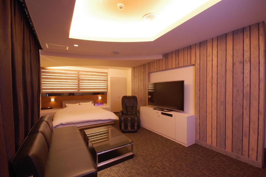 une chambre avec un lit et une télévision à écran plat dans l'établissement Hotel Y's (Adult Only), à Sapporo