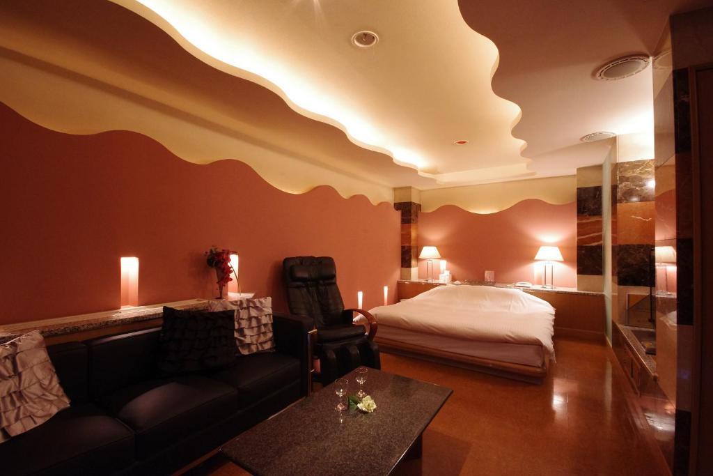 une chambre d'hôtel avec un lit et un canapé dans l'établissement Hotel Y's (Adult Only), à Sapporo