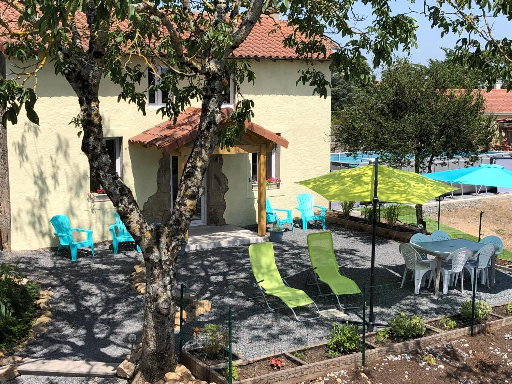 un patio avec des chaises, des tables et des parasols dans l'établissement The Walnut Tree Gite, au Dorat