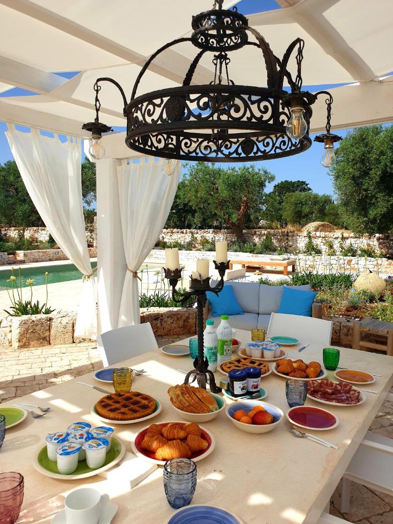 une table avec des assiettes de nourriture dans l'établissement Trulli Ad Maiora, à Alberobello