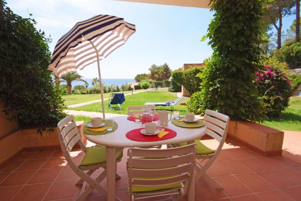 une table et des chaises avec un parasol sur une terrasse dans l'établissement Casa Del Golfo, à Lacona