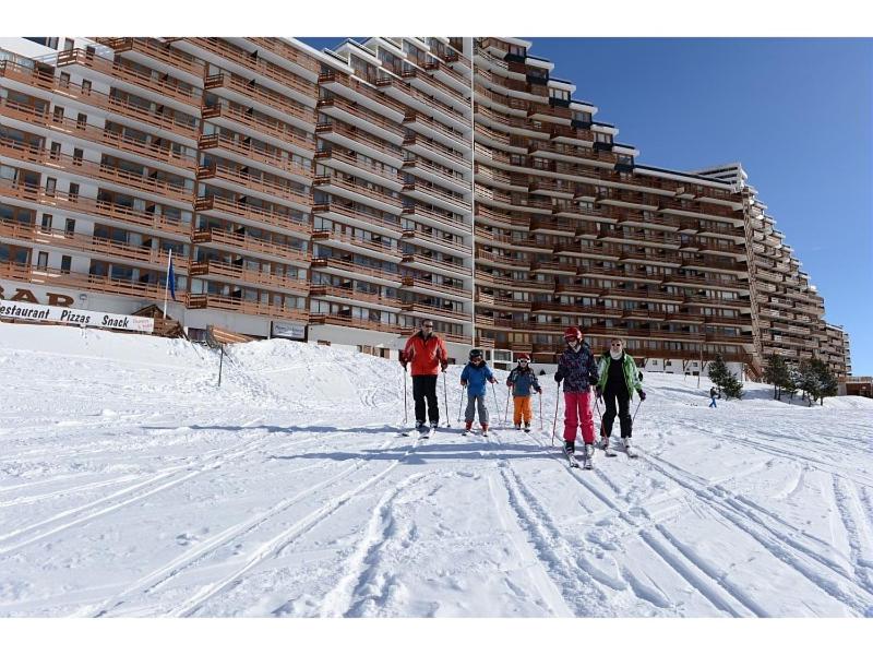 un groupe de personnes à skis dans la neige devant un bâtiment dans l'établissement Studio au pied des pistes + Cellier, à La Mongie