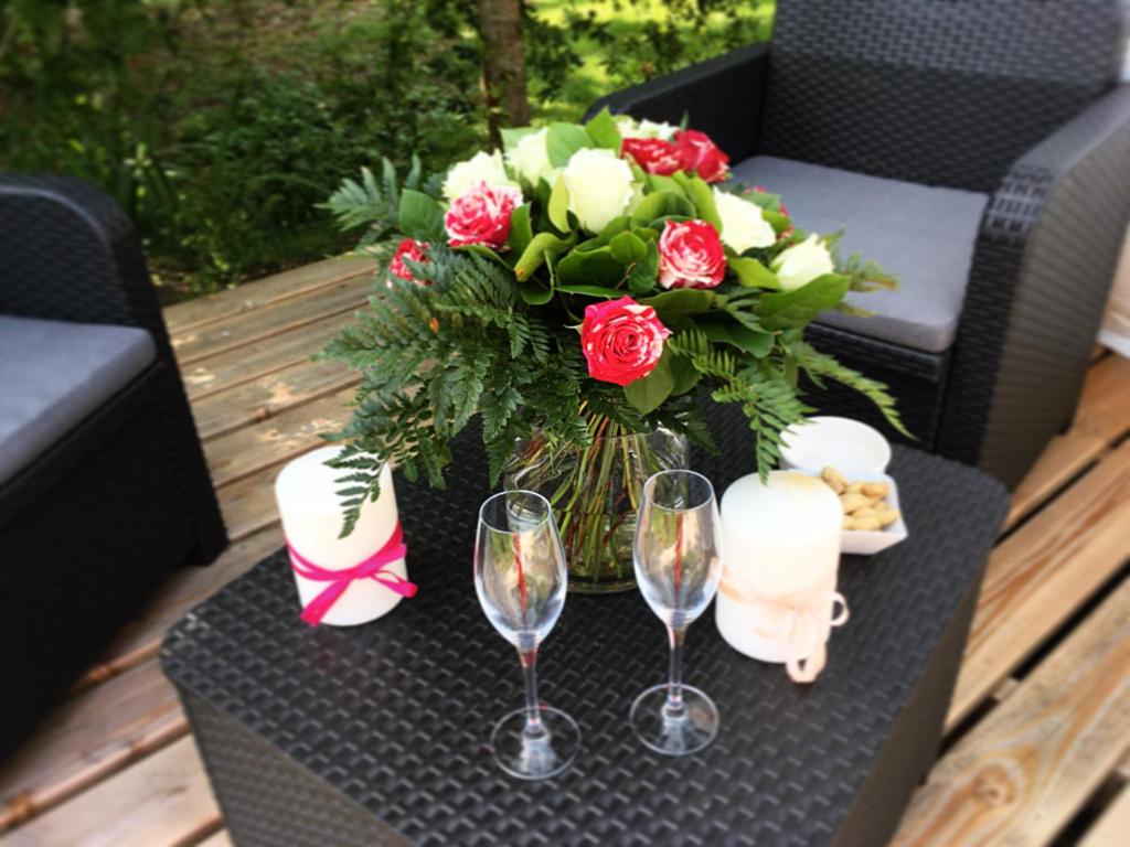 - une table avec des verres à vin et un bouquet de roses dans l'établissement domaine des butineuses, à Marchainville