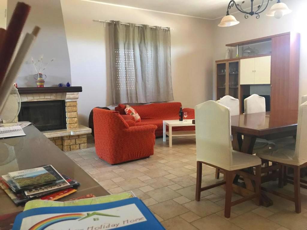 un salon avec un canapé rouge et une table dans l'établissement I Colori degli Agrumi Holiday Home, à Floridia